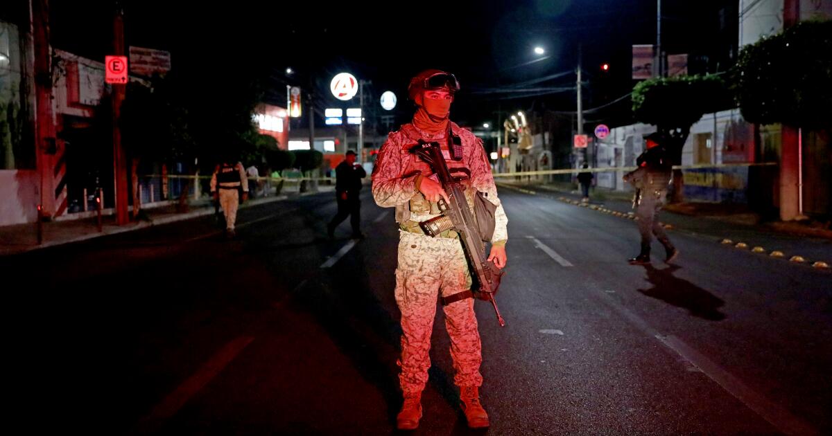 CELAYA, GUANAJUATO - MAY 13: A member of the Mexican Army stands guard at the scene where a taxi driver was shot and killed along Calle General Mariano Jimenez in Colonia La Joya on Tuesday, May 13, 2025 in Celaya, Guanajuato. The taxi driver was driving with his daughter during the time of the homicide causing him to lose control of the car flipping over. The daughter was not injured. The most dangerous place in North America to be a police officer is the Mexican state of Guanajuato, where each year about 65 cops are gunned down. As Mexico has militarized its war on organized crime, vastly expanding the ranks and power of its army, navy and national guard, efforts to professionalize the nation's thousands of municipal police forces have fallen by the wayside. (Gary Coronado / For The Los Angeles Times)