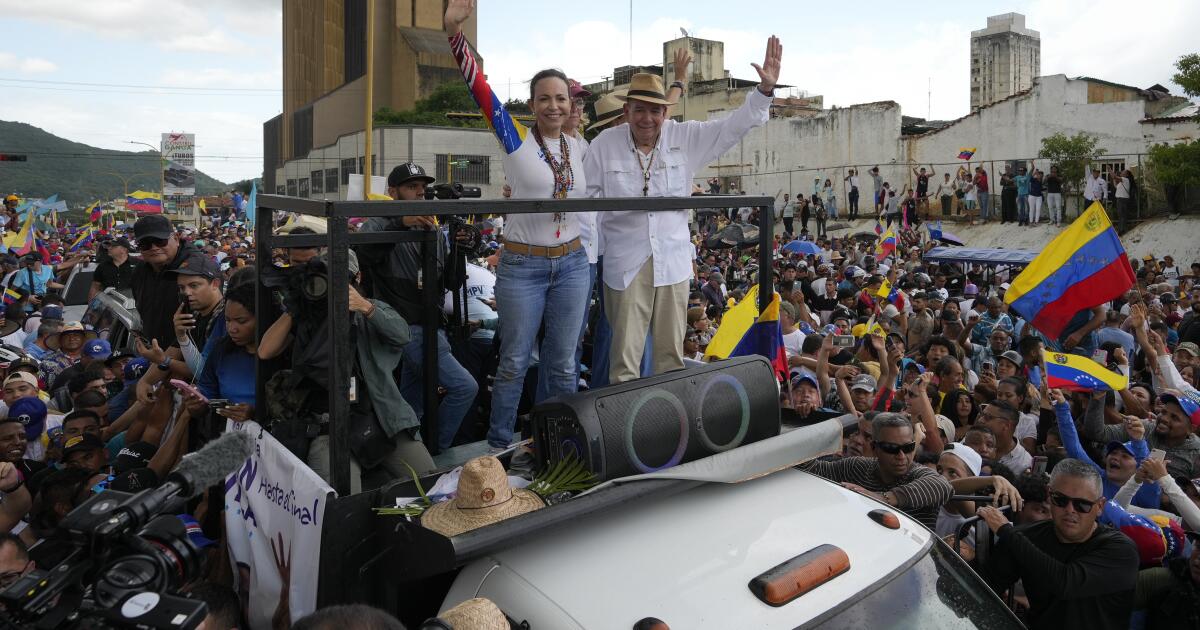 Venezuelan presidential candidate Edmundo Gonzalez, right, and opposition leader Maria Corina Machado parade on a truck transporting them through a crowd of supporters during a campaign rally in Valencia, Venezuela, Saturday, July 13, 2024. (AP Photo/Ariana Cubillos)