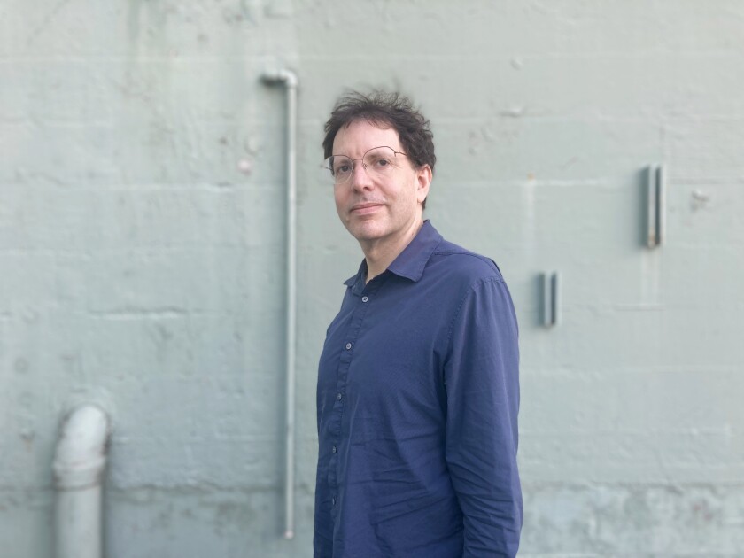 Douglas Wolk stands outside and looks into the camera
