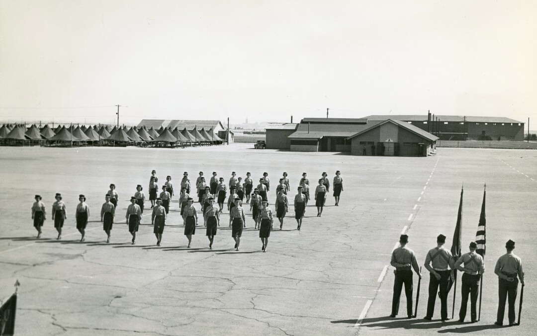 Women Marines march in formation on the parade ground at Marine Corps base