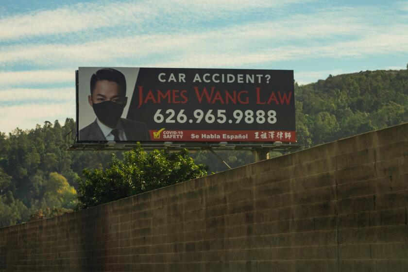 WHITTIER, CA - DECEMBER 09: A large billboard featuring personal injury attorney James Wang is seen along the Pomona Freeway on Wednesday, Dec. 9, 2020 in Whittier, CA. Wang, a native of Diamond Bar, has over 20 billboards throughout Los Angeles County, but starting putting masks on a few them to raise awareness of the need to mask up in the middle of a pandemic (Kent Nishimura / Los Angeles Times)