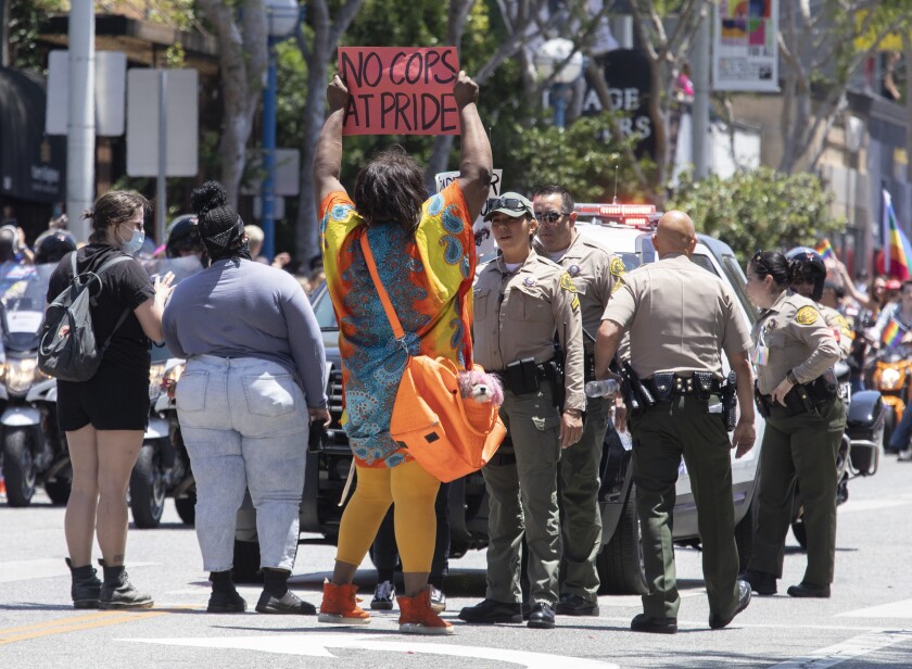 People speak to sheriff's deputies at a Pride event