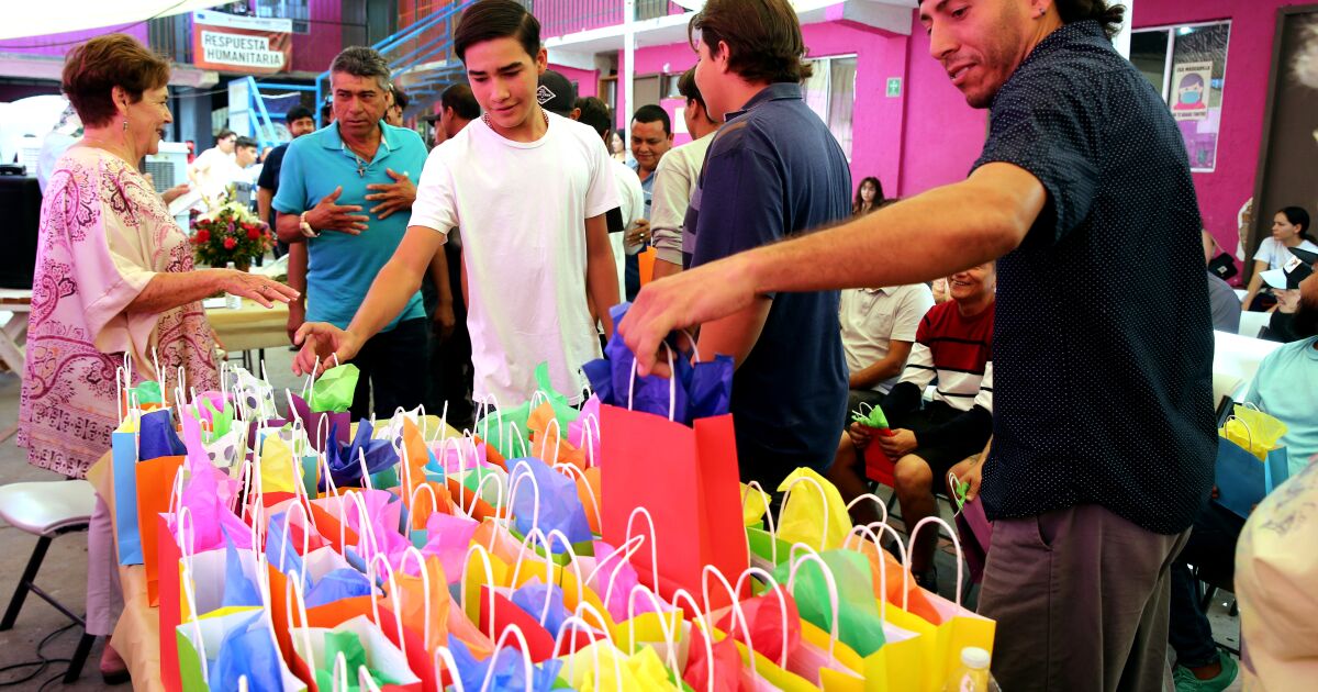 Refugee Juan Carlos Manzo Manzo, right, grabs one of the gift bags each father received for Father's Day at refugee shelter Cobina Posada Del Migrante in Mexicali, Mexico, on Saturday, June 24, 2023. The shelter, five minutes from the Mexico/USA border, houses families who are waiting for their refugee applications to be processed in the United States.