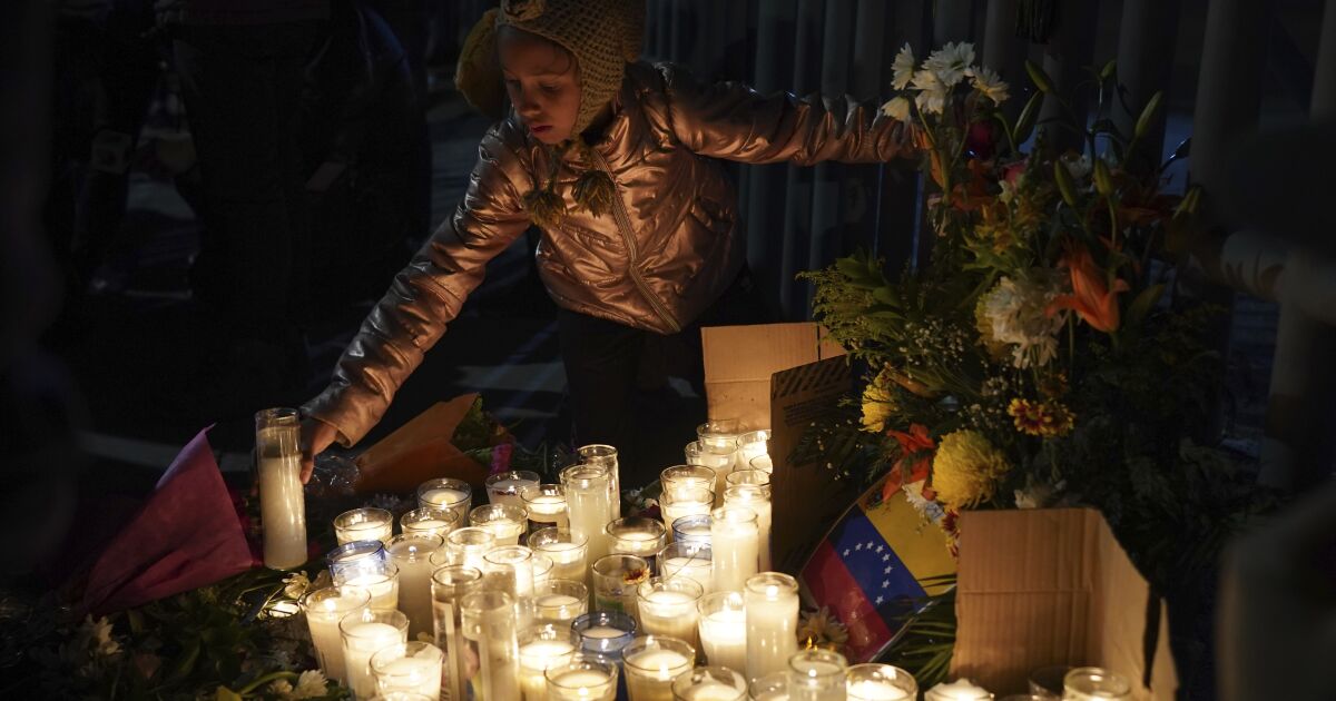 A Venezuelan migrant girl lights a candle during a vigil for the victims of a fire at an immigration detention center that killed dozens, in Ciudad Juarez, Mexico, Tuesday, March 28, 2023. According to Mexican President Andres Manuel Lopez Obrador, migrants fearing deportation set mattresses ablaze at the center, starting the fire. (AP Photo/Fernando Llano)