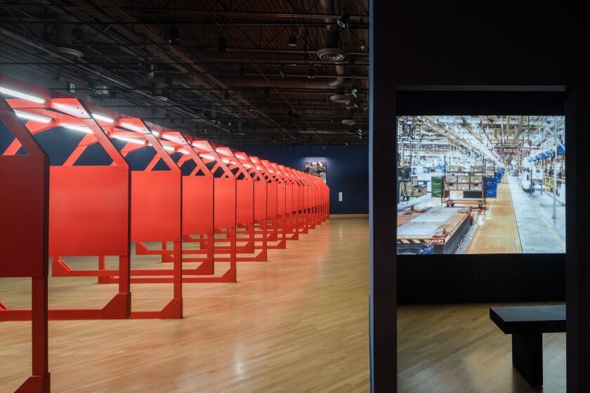 A video plays in a small room beside photo display panels.