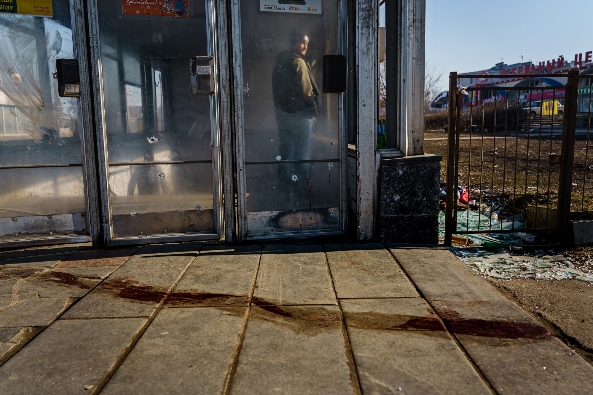 A stain on the ground in front of glass doors