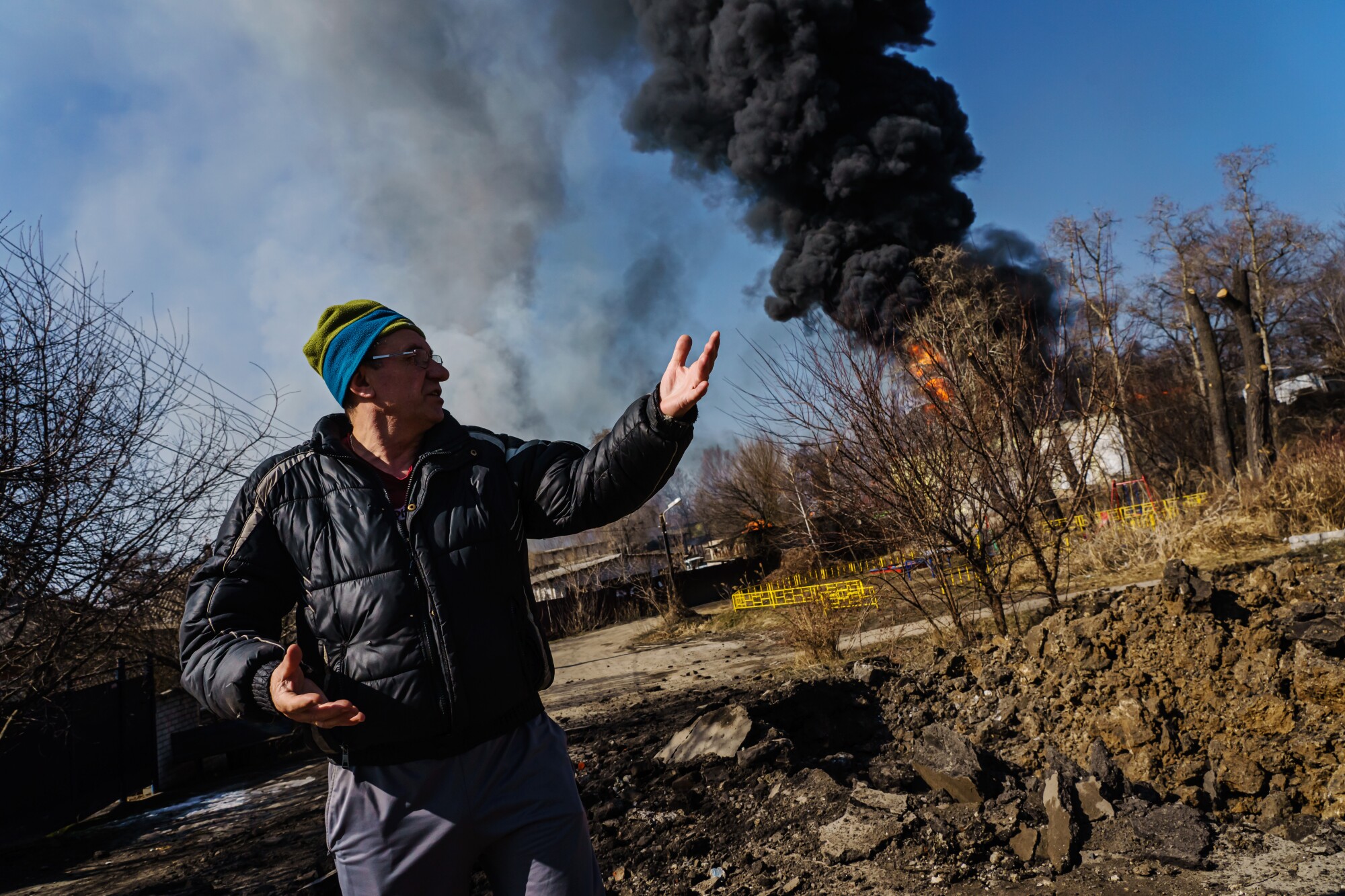 A man in a crater with fire in the background
