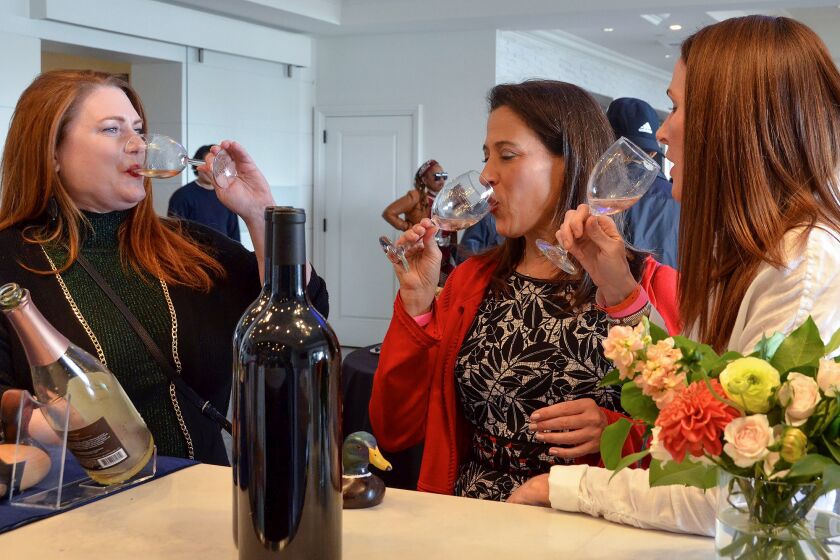 From left, Carolyn Barrett, Ellen Norris and JulIa Dupps sample wine from The Duckhorn Portfolio of N.American wines during the Newport Beach Wine & Spirits Festival at the Balboa Bay Resort on Saturday.
