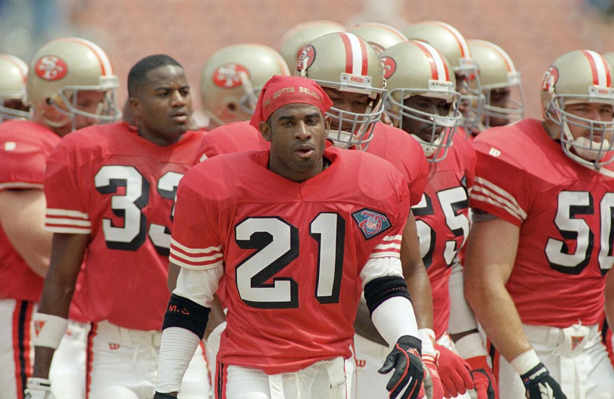 Deion Sanders leads the 49ers onto the field.