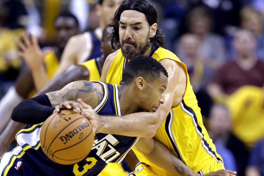 Pacers forward Luis Scola knocks the ball away from Jazz guard Trey Burke during the second half of their game Monday night in Indianapolis.
