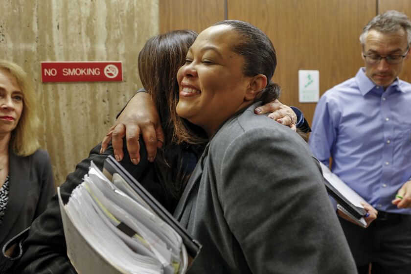 Samara Herard, right, hugs Deputy Dist. Atty. Beth Silverman before speaking to the media about the guilty verdict for Lonnie Franklin Jr. Herard's sister, Princess Berthomieux, 15, was found strangled and beaten March 19, 2002, in an Inglewood alley.