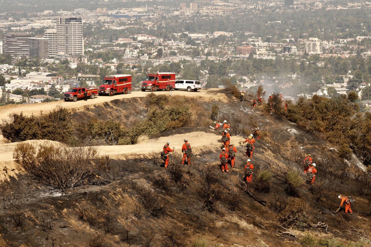 An inmate crew puts out hot spots Monday in the 45-acre brush fire in Eagle Rock.