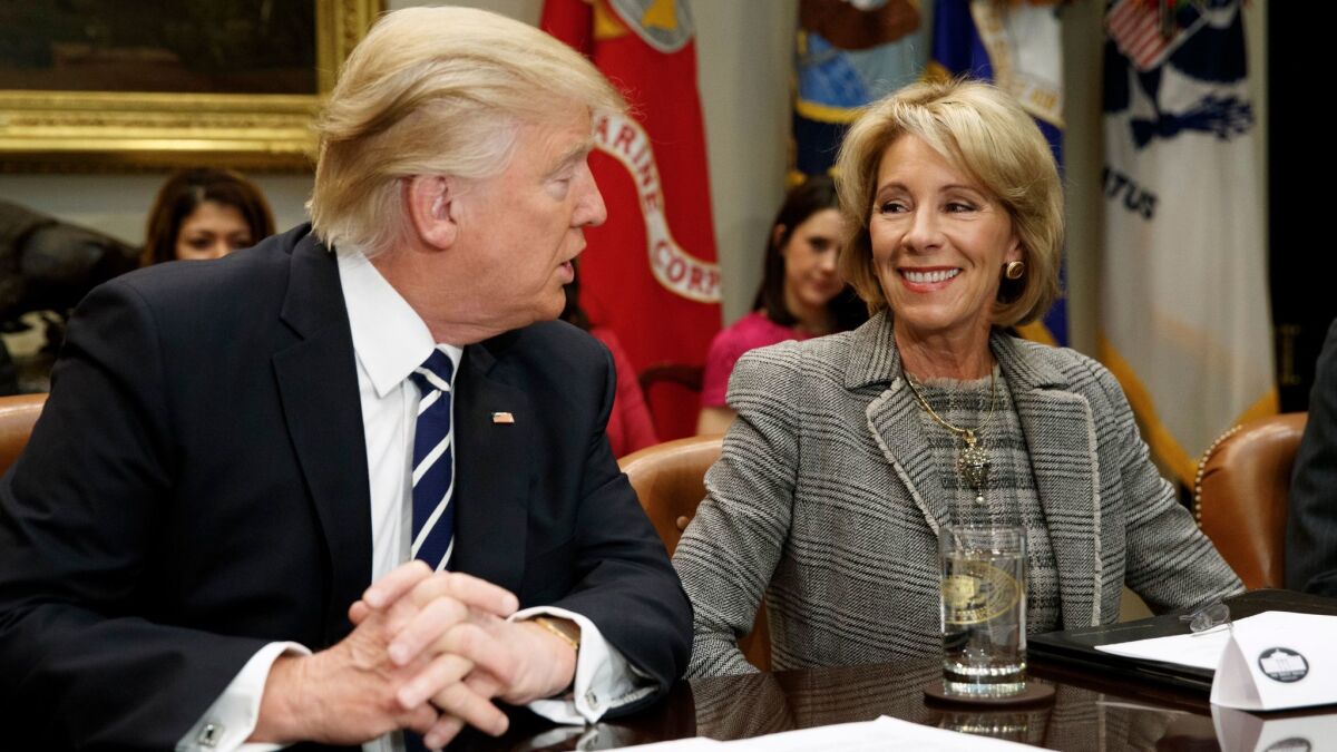 President Donald Trump looks and Education Secretary Betsy DeVos at a meeting with parents and teachers in the Roosevelt Room of the White House on Feb. 14.