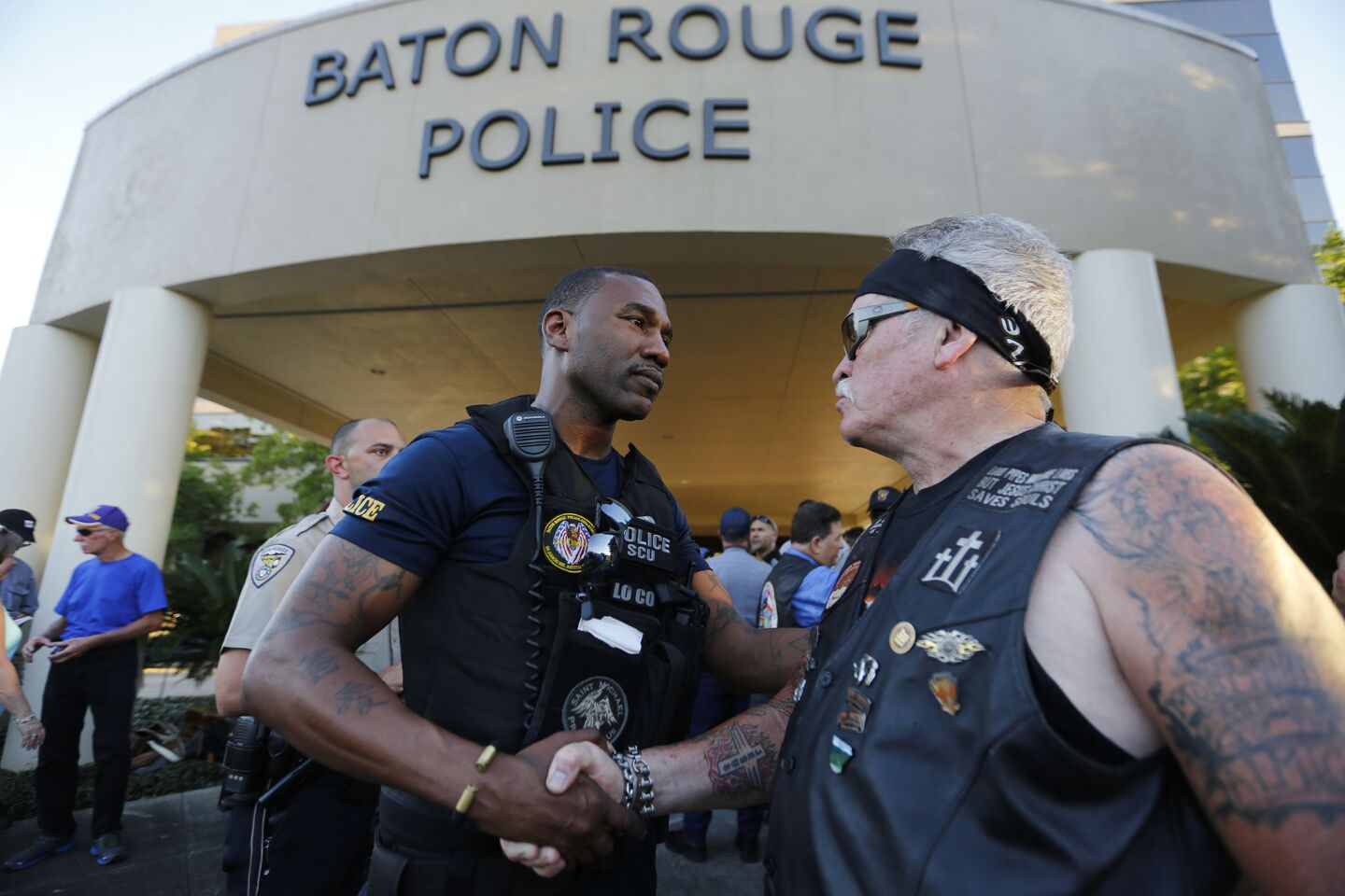 Baton Rouge Police Officer Lorenzo Coleman is greeted by biker Fowler Montgomery with In The Wind Ministries after a rally with nearly 400 motorcycle riders from various local clubs who rode to police headquarters to show thier support.