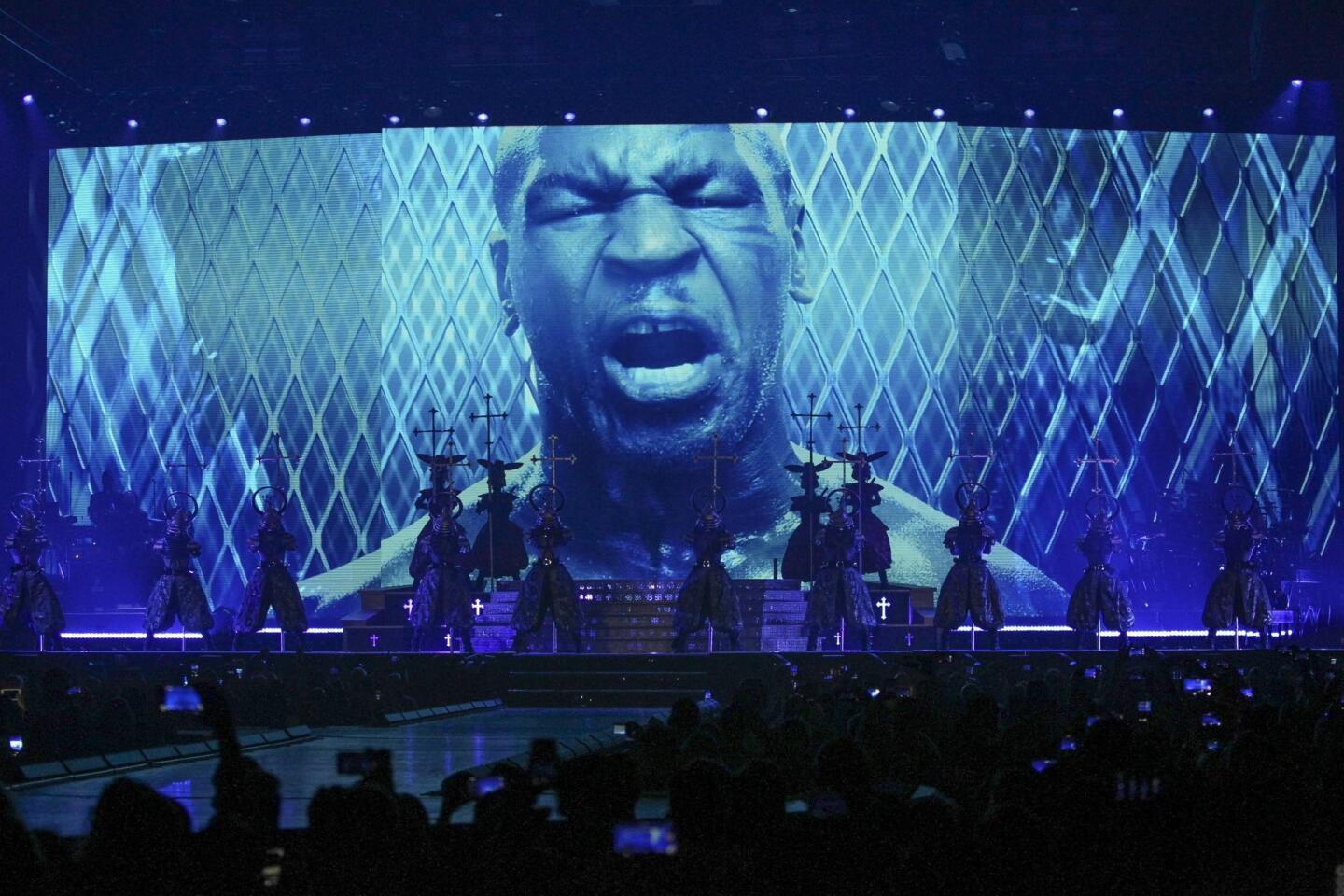 Mike Tyson is projected on a large screen above dancers before Madonna appears .
