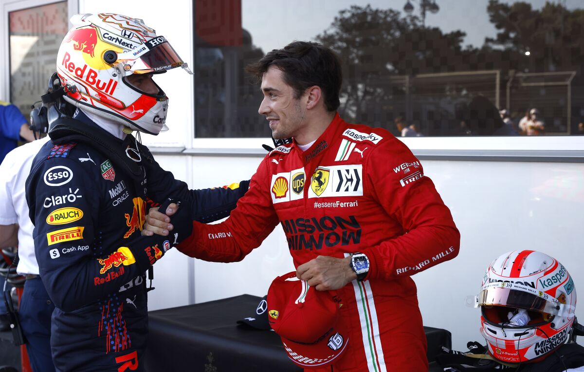 Ferrari driver Charles Leclerc of Monaco, right, is congratulated by Red Bull driver Max Verstappen of the Netherlands after taking pole position during the qualifying session at the Baku Formula One city circuit in Baku, Azerbaijan, Saturday, June 5, 2021. The Azerbaijan Formula One Grand Prix will take place on Sunday. (Maxim Shemetov, Pool via AP)