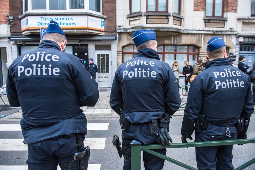 Police officers stand guard in the Schaerbeek district in Brussels during an anti-terrorism operation on March 25.