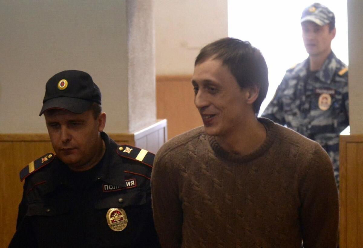 Pavel Dmitrichenko, a leading dancer at Russia's Bolshoi Ballet, is escorted to a courtroom for a hearing in Moscow on Tuesday.