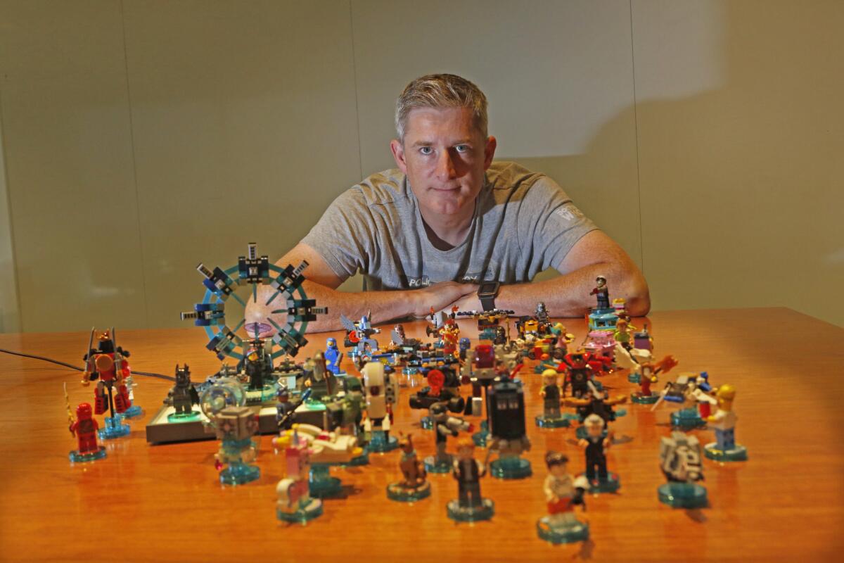 Warner Brothers executive Jon Burton poses for a portrait with his Lego Dimensions toys at Warner Brothers in Burbank on Sept. 11, 2015.