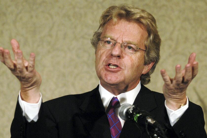 Jerry Springer raises his palms while speaking