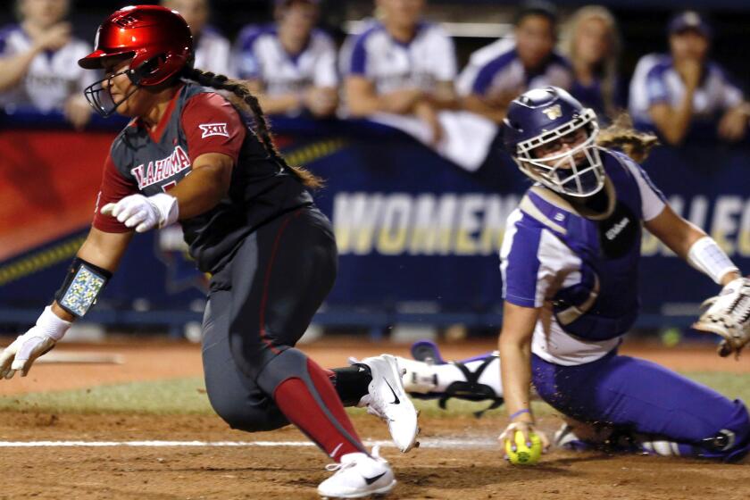 Oklahoma's Fale Aviu avoids the tag of Washington's Morganne Flores on a squeeze bunt in the second inning of a Women's College World Series softball game in Oklahoma City, Friday, June 2, 2017. (Sarah Phipps/The Oklahoman via AP)