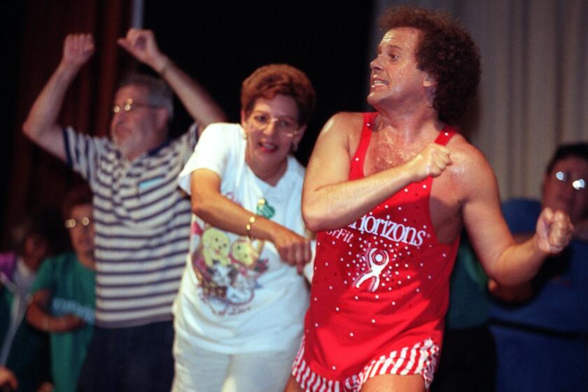 Fitness guru Richard Simmons leads a group of seniors in an exercise routine at Long Beach Memorial Medical Center on June 16, 1998 at the Secure Horizons Wellness Festival. This is the 70-to-80-year-old group exercising with him.