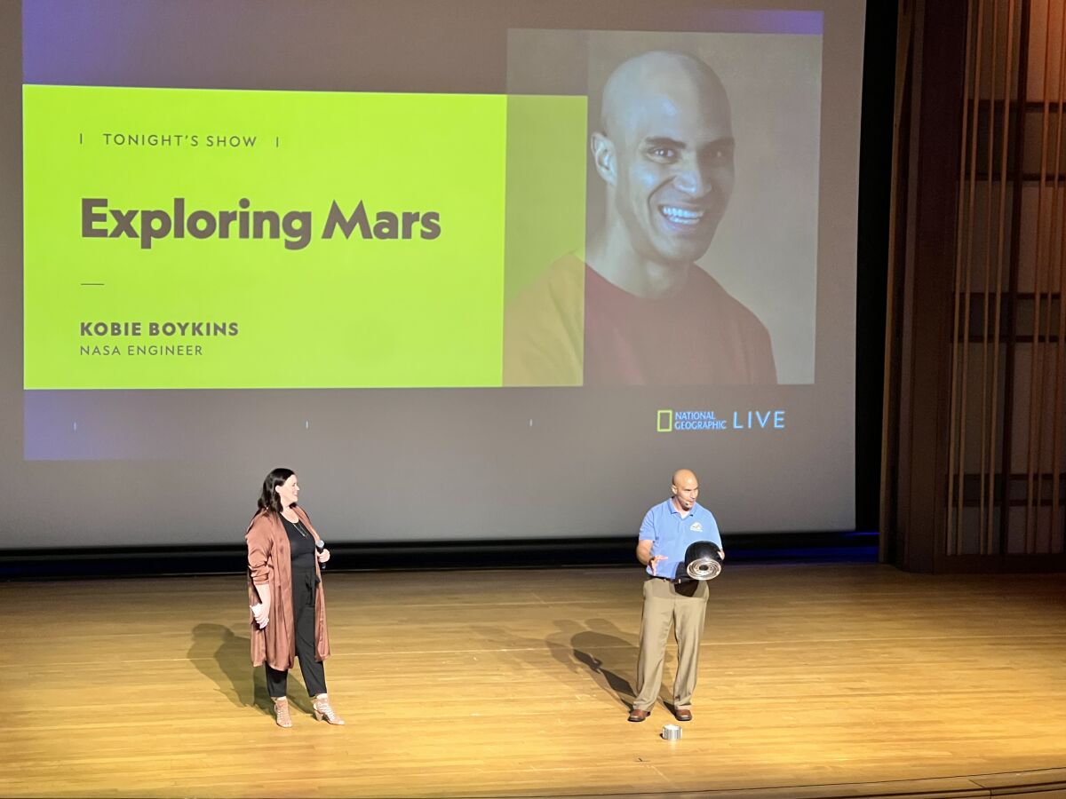 Allison Boles, La Jolla Music Society director of learning and engagement, stands onstage with NASA engineer Kobie Boykins.