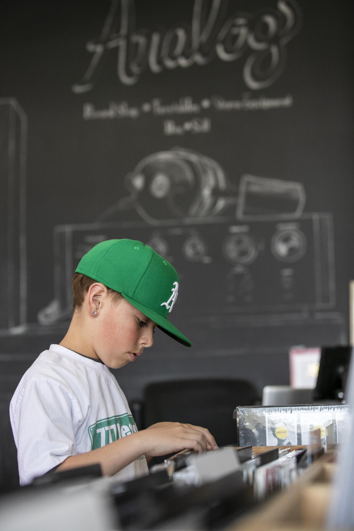Twelve-year-old Asaph Dougherty, 12, shops for records at Analog Record Shop.