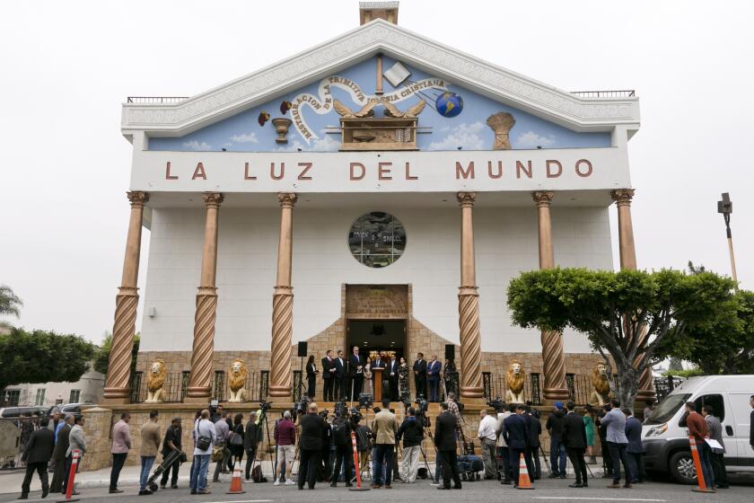 Members of the media gather for a news conference outside the East Los Angeles temple of La Luz del Mundo Friday, June 7, 2019. The lawyers spoke Friday outside an east Los Angeles temple of La Luz del Mundo with Joaquín García's family standing beside them, calling their client innocent of "false charges." (AP Photo/Damian Dovarganes)
