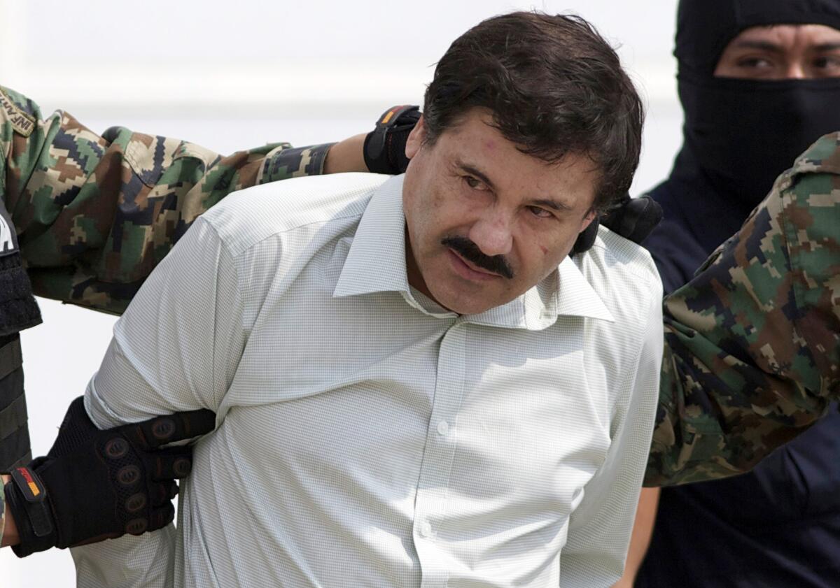 Joaquín "El Chapo" Guzmán, el jefe del cártel de Sinaloa de México, es escoltado hasta un helicóptero después de su captura en 2014.