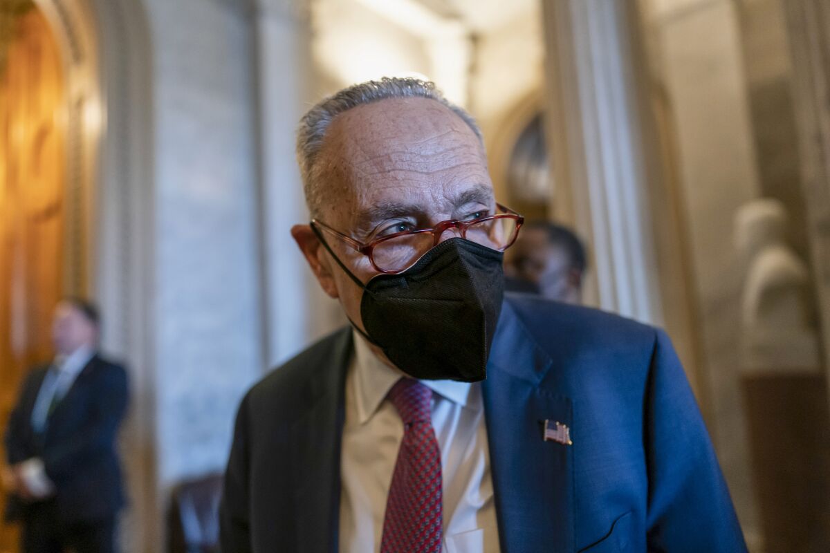  Chuck Schumer is shown in a Senate hallway wearing a mask