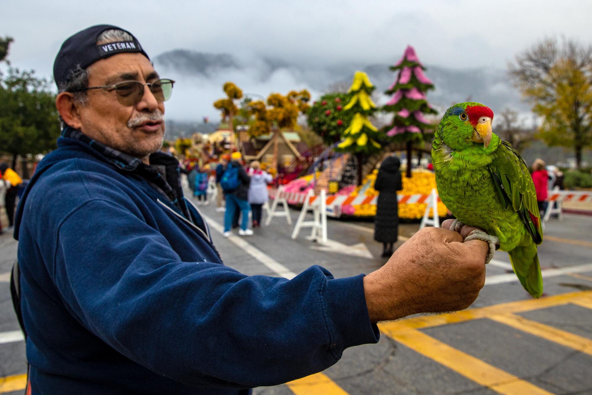 A man holds a parrot on his arm