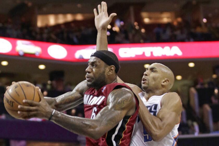 Miami's LeBron James is fouled by Charlotte's Gerald Henderson at Time Warner Cable Arena on Saturday.