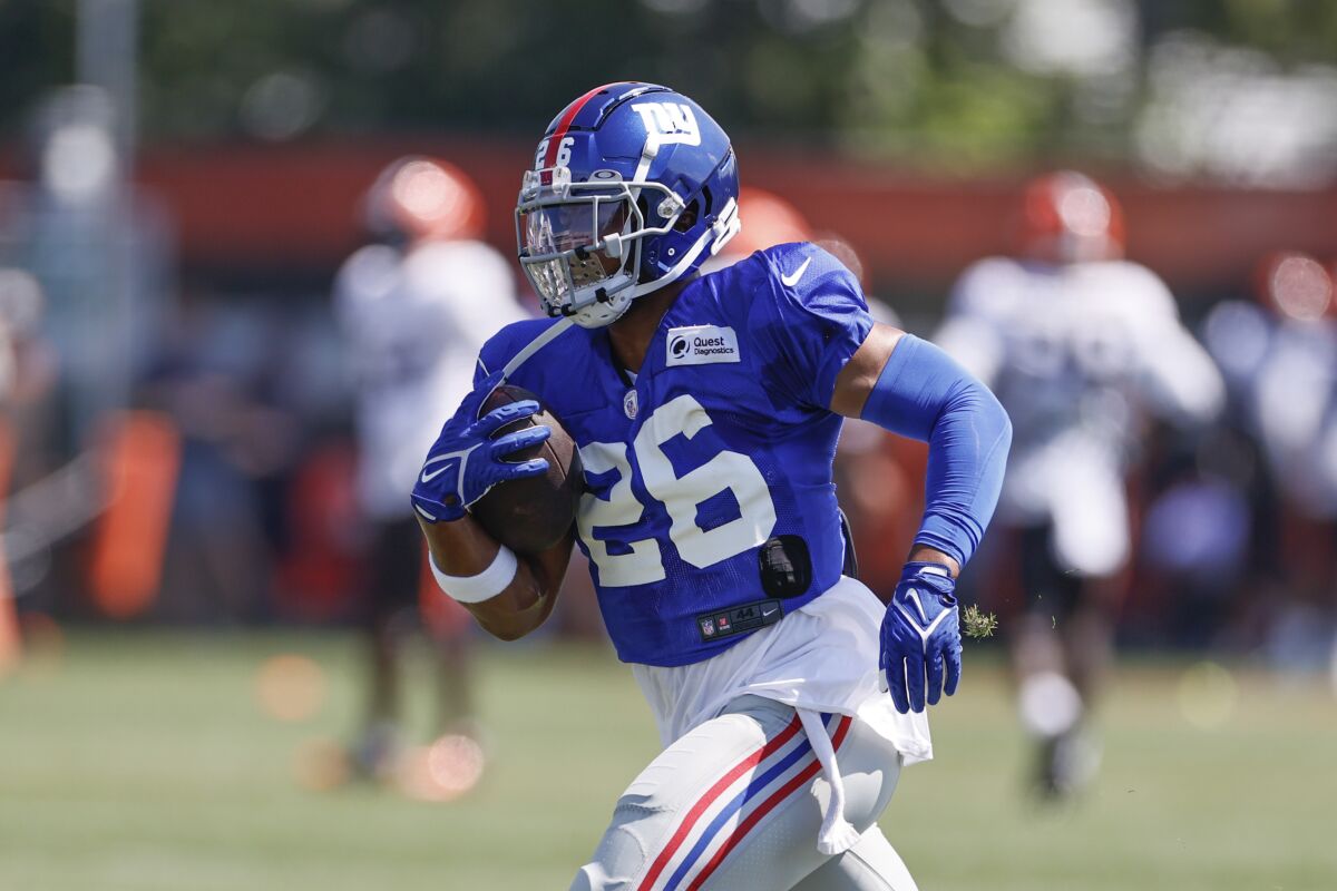 FILE - In this Friday, Aug. 20, 2021, file photo, New York Giants running back Saquon Barkley (26) runs through a drill during a joint NFL football training practice with the Cleveland Browns in Berea, Ohio. (AP Photo/Ron Schwane, File)