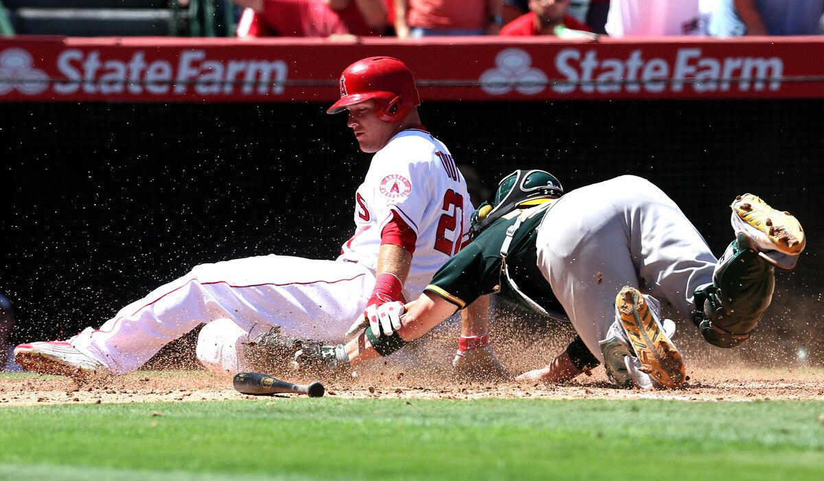Angels center fielder Mike Trout is tagged out by A's catcher Derek Norris for the final out in a six-run second inning Sunday. Trout had a two-run single in the rally and hit a solo home run in the seventh inning.