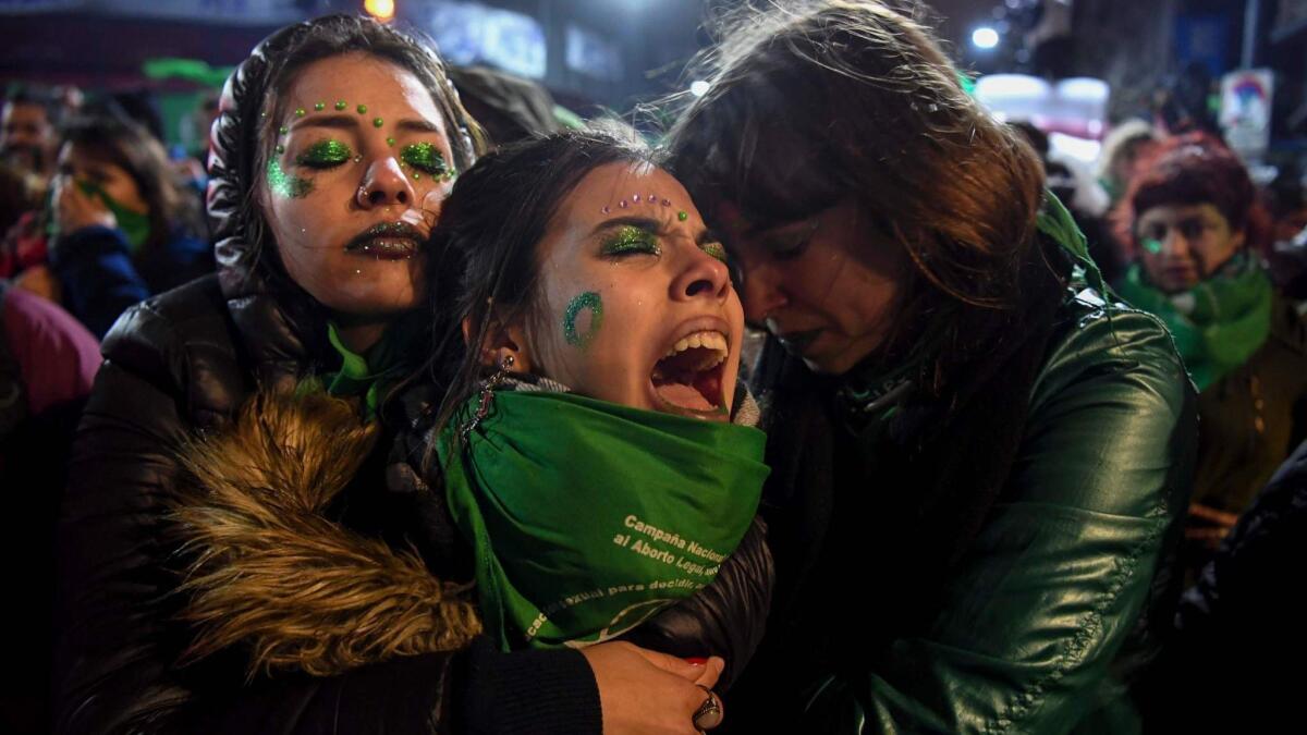 Activists in favor of legal abortion comfort one another Thursday outside the National Congress in Buenos Aires.