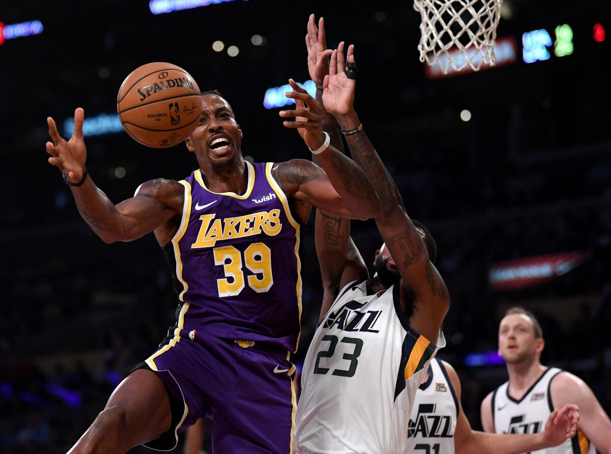 Lakers center Dwight Howard, left, grabs a rebound in front of Utah Jazz forward Royce O'Neale during the first half of Friday's win.