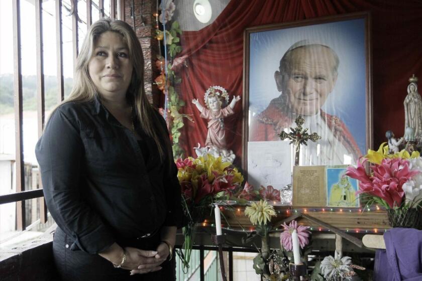 Floribeth Mora in front of a shrine to Pope John Paul II in Costa Rica. Mora was healed of a brain aneurysm, a cure that the Catholic Church is citing to advance John Paul II's path to sainthood.