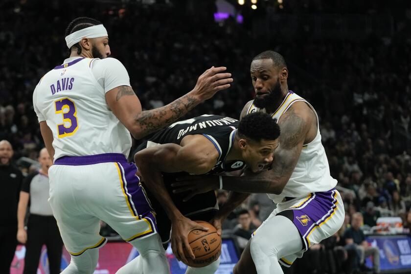 Milwaukee Bucks' Giannis Antetokounmpo drives between Los Angeles Lakers' LeBron James and Anthony Davis during the first half of an NBA basketball game Friday, Dec. 2, 2022, in Milwaukee. (AP Photo/Morry Gash)