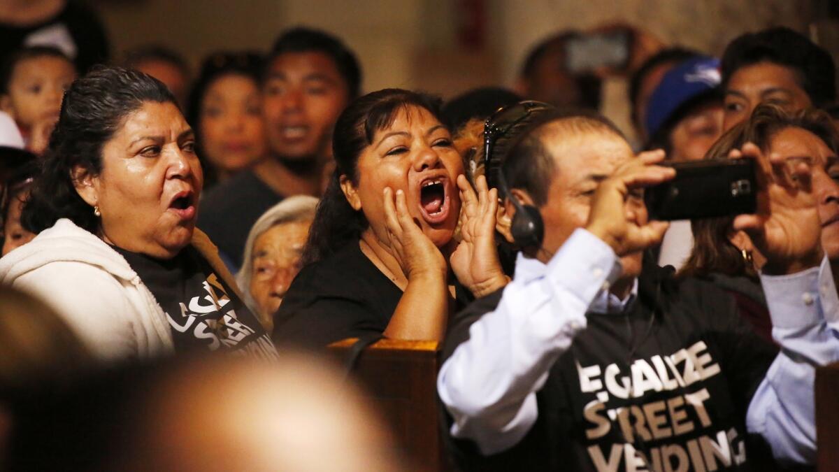 Street vendors in the audience call out as the L.A. City Council discusses the vote to pass an ordinance on street vending in which brick-and-mortar businesses could offer input to try to stop vendors from setting up shop on nearby sidewalks.