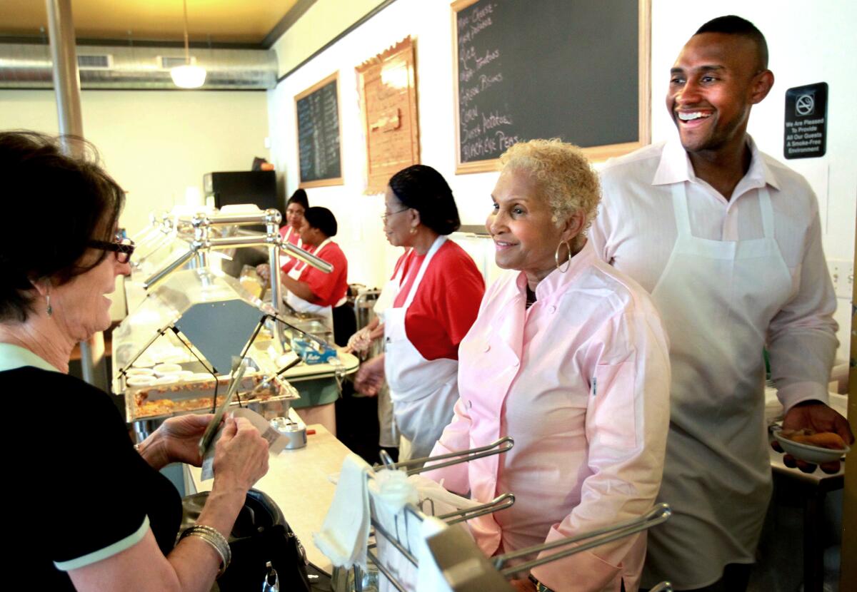 FILE - A customer picks up food from Sweetie Pie's owner Robbie Montgomery, second right, and Montgomery's son, James "Tim" Norman, right, at the shop in St. Louis, on April 19, 2011. A St. Louis jury on Friday, Sept. 16, 2022, convicted Norman, a former star of the reality TV show “Welcome to Sweetie Pie’s,” of arranging the shooting death of his nephew. (David Carson/St. Louis Post-Dispatch via AP, File)