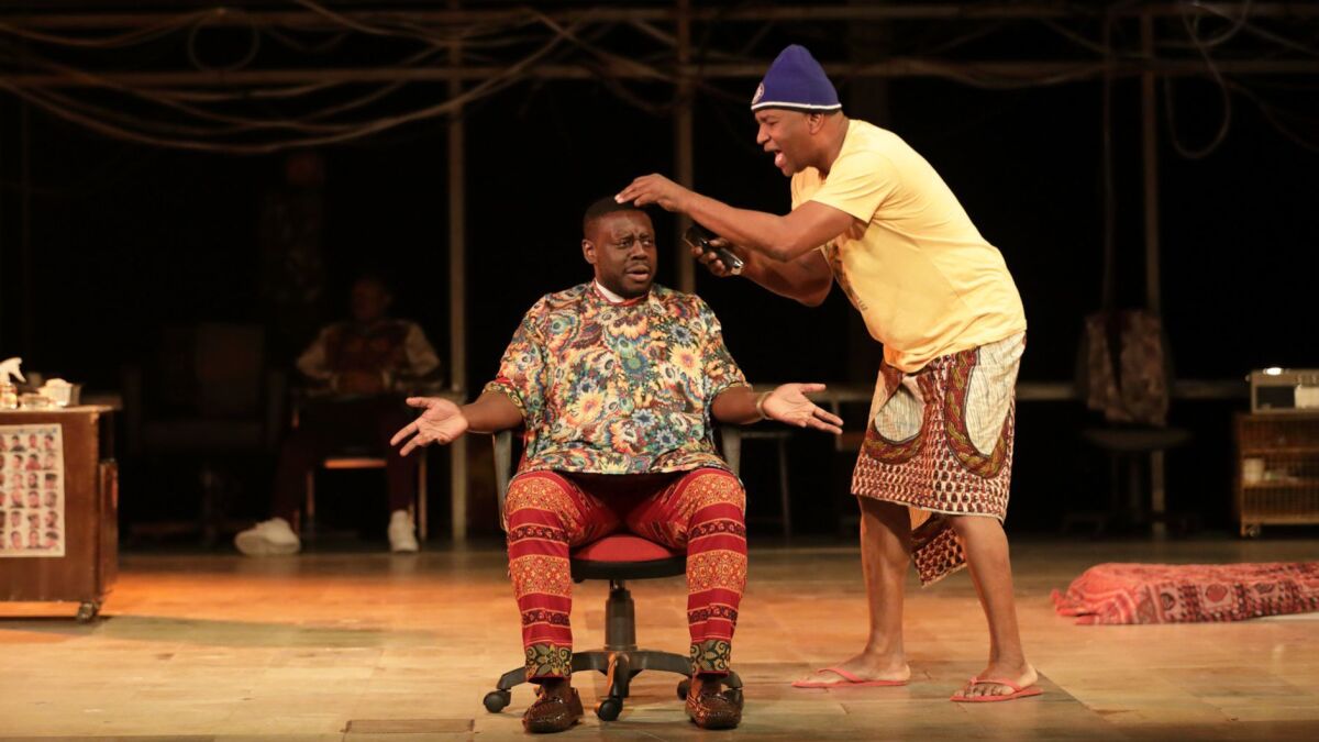 Ekow Quartey, seated, and Patrice Naiambana in "The Barber Shop Chronicles," playing at the Freud Playhouse at UCLA. The play is an import from England about African immigrants bonding at barbershops in London and Africa.