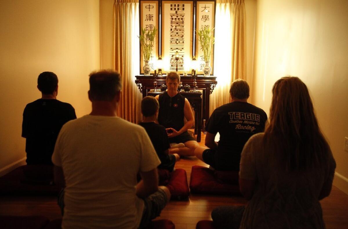 Students meditate during a class at the Ekata fitness center in Valencia.