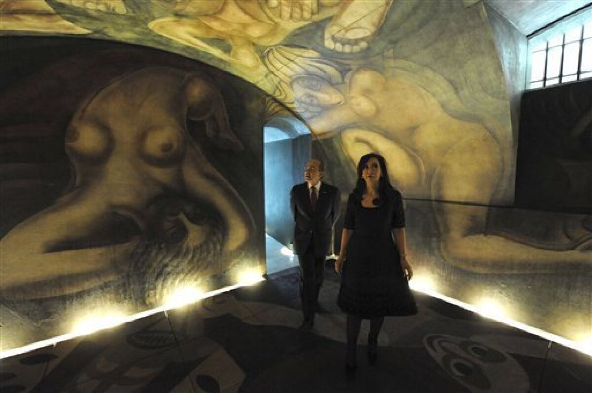 In this picture released by Argentina's Presidential Press Office, Argentina's President Cristina Fernandez, right, accompanied by Mexican President Felipe Calderon walk along the mural entitled "Ejercicio Plastico" by Mexican artist David Siqueiros after its inauguration, in Buenos Aires, Argentina, Friday, Dec. 3, 2010. The mural which spent years under restoration, has been placed at the future Museum of Political Arts, a former underground customs facility, next to the government house. (AP Photo/Argentine Presidential Press Office)