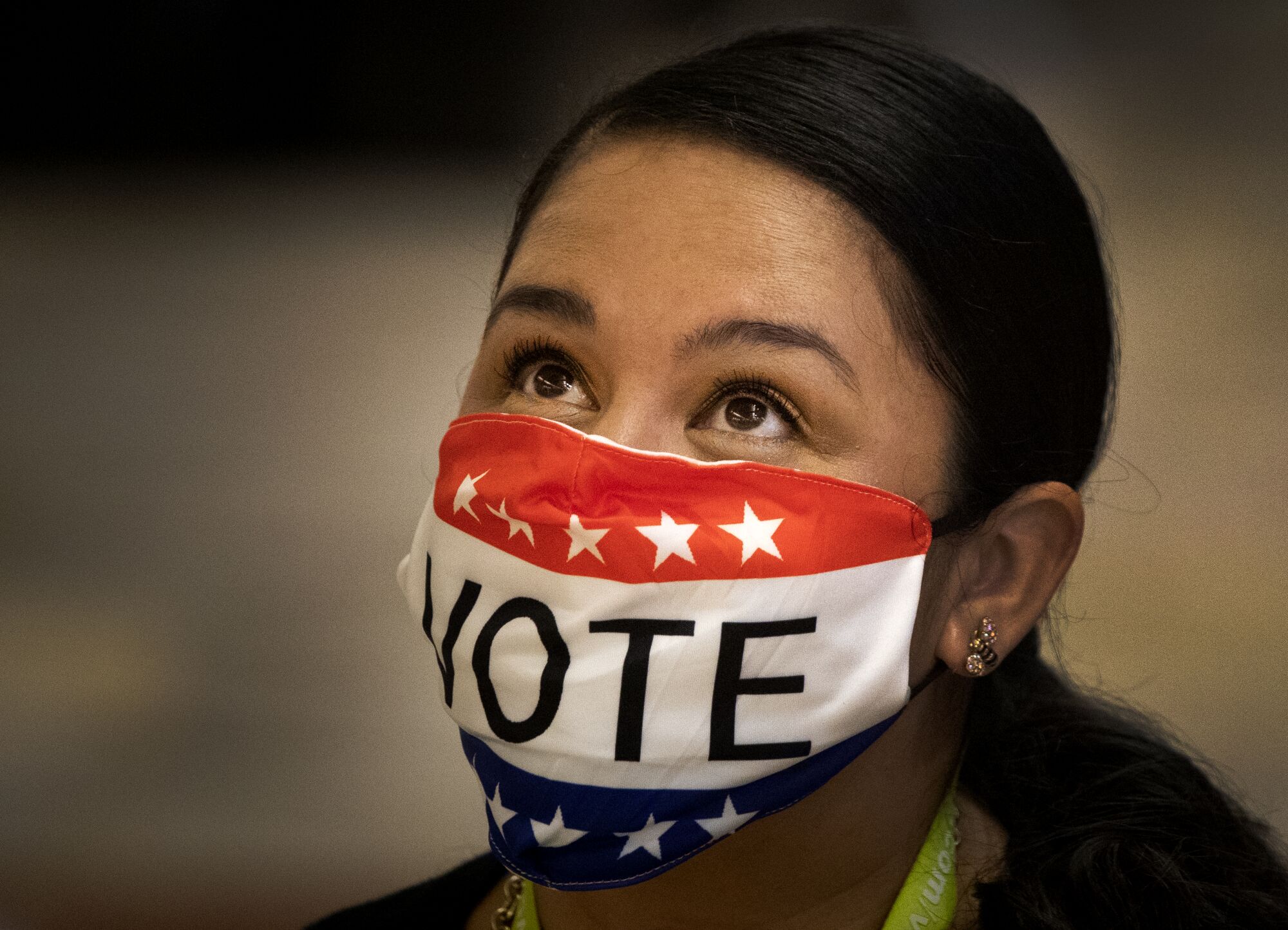Election worker Melissa Balderas wears a vote mask while assisting early voters at the Honda Center in Anaheim on Nov. 2. 