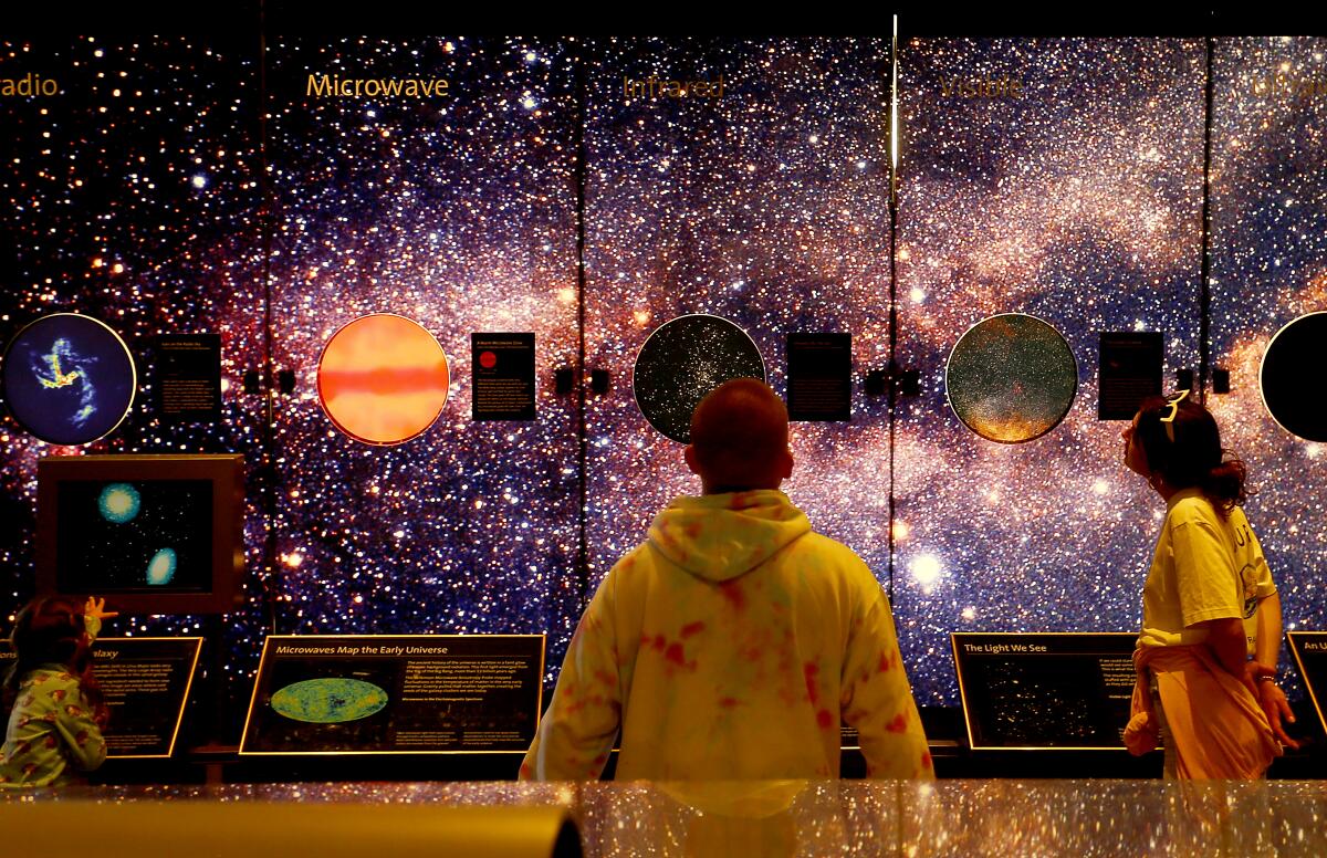 A boys studies a space exhibit at Griffith Observatory.