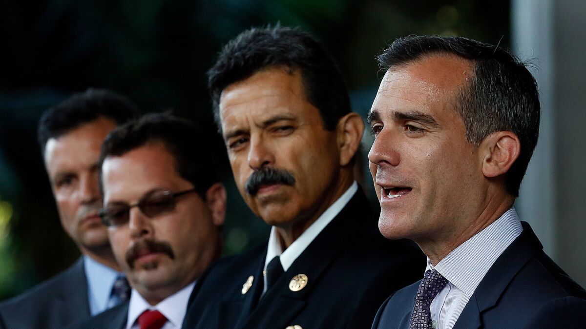 L.A. Mayor Eric Garcetti, right, stands next to city Fire Chief Ralph M. Terrazas. Terrazas said in a staff memo that Fire Marshal John Vidovich will step down next month.
