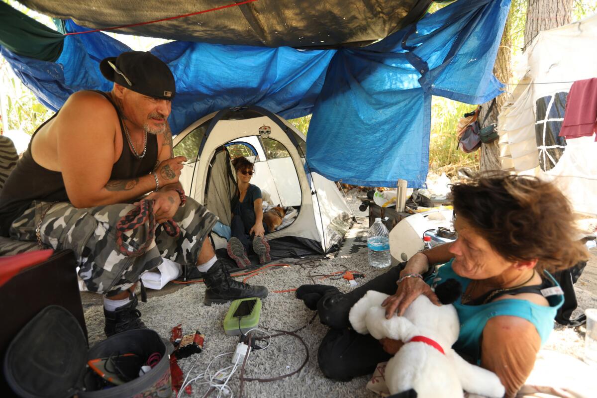 Frlom left, Justin Reeves, 46; Melissa Millner, 46; and Sandy Brown, 55, share an encampment on an island in the middle of the L.A. River near Atwater Village.