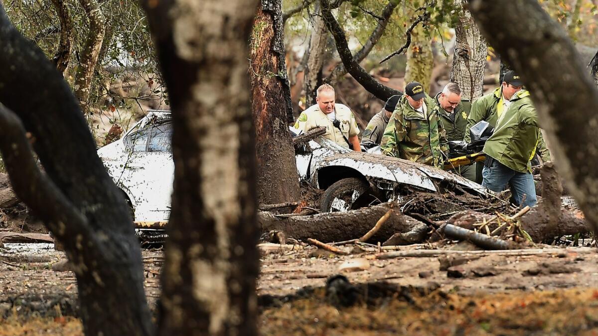 Sheriffs deputies carry a body from the debris near Hot Springs Road in Montecito.