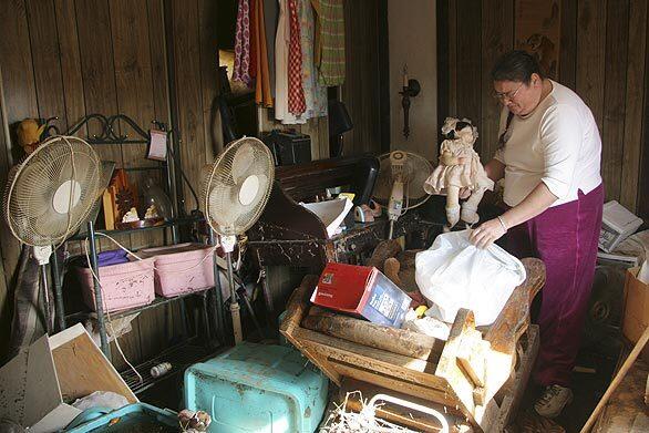 A teary Suzanne Galla picks through her daughters waterlogged belongings in the family trailer in Piedmont, Mo. About one-third of the town of 2,000 is underwater.